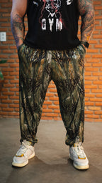 Model wearing camo balloon pants and white sneakers against a brick wall background