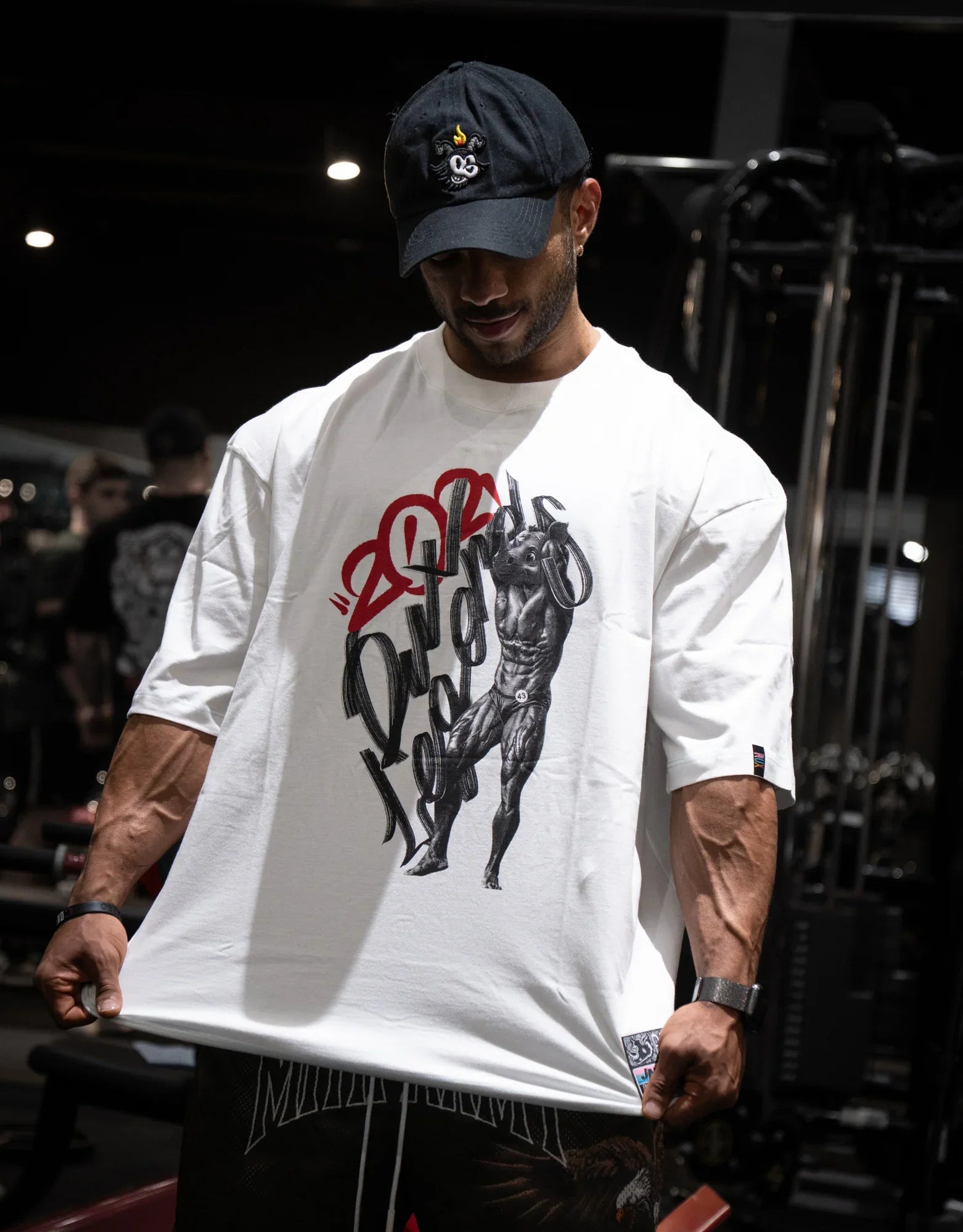 Model wearing black and off-white pants in a gym setting