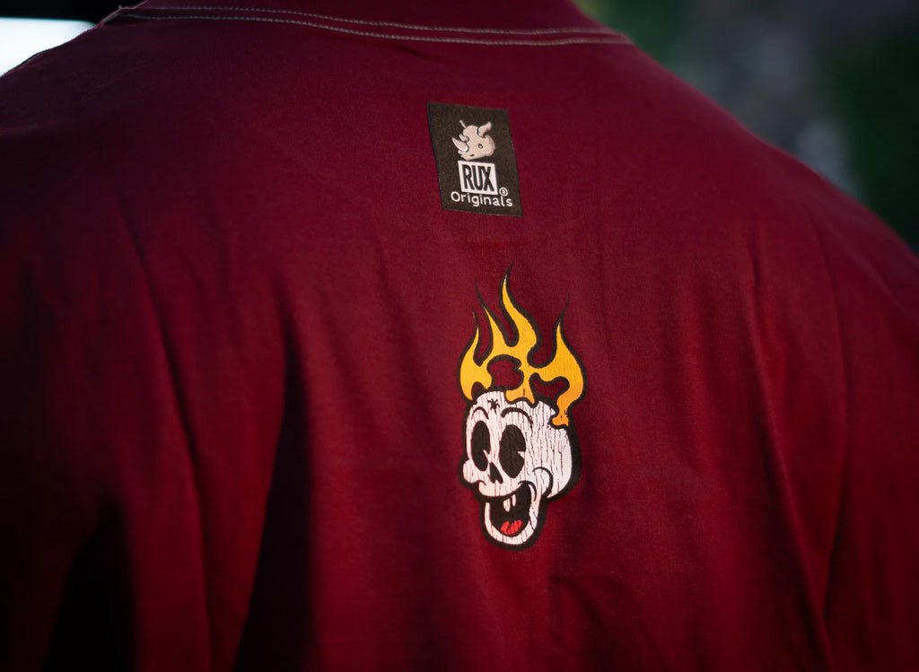Back view of maroon shirt with flaming cartoon skull graphic and Rux Originals label