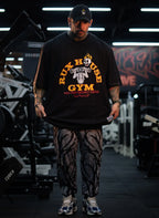 Model wearing patterned gym pants and sneakers in a gym setting