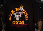 Model wearing black t-shirt with Rux House Gym skeleton weightlifting graphic.