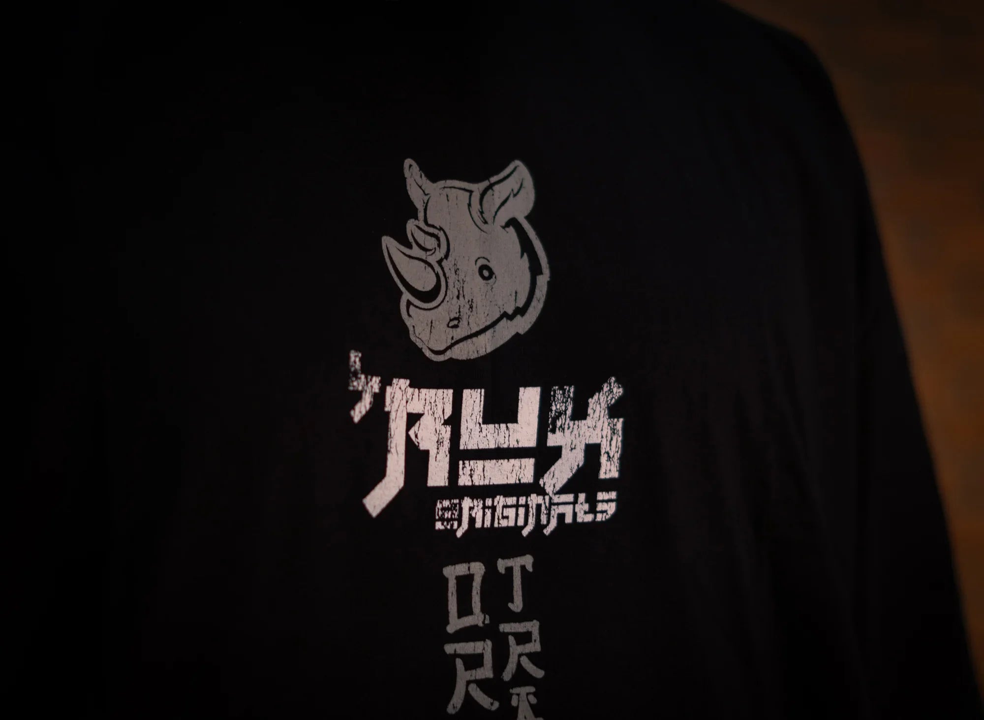 Close-up of black shirt with distressed rhino graphic and Japanese text print