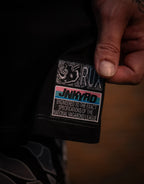 Model wearing black pants, closeup of colorful patch with rhino graphic and text details