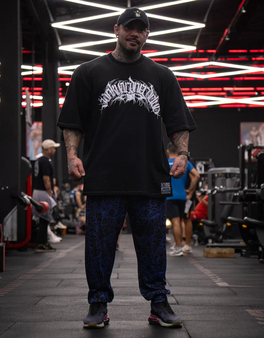 Model wearing patterned blue pants in a gym setting