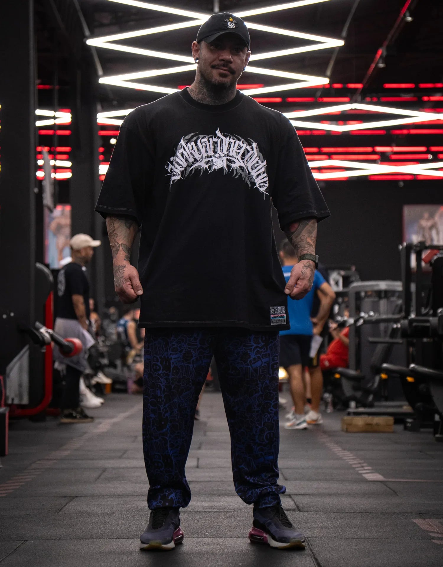 Model wearing patterned blue pants in a gym setting