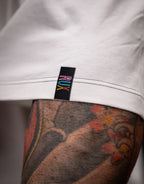 Model wearing off-white pants with visible tag and leg tattoo detail