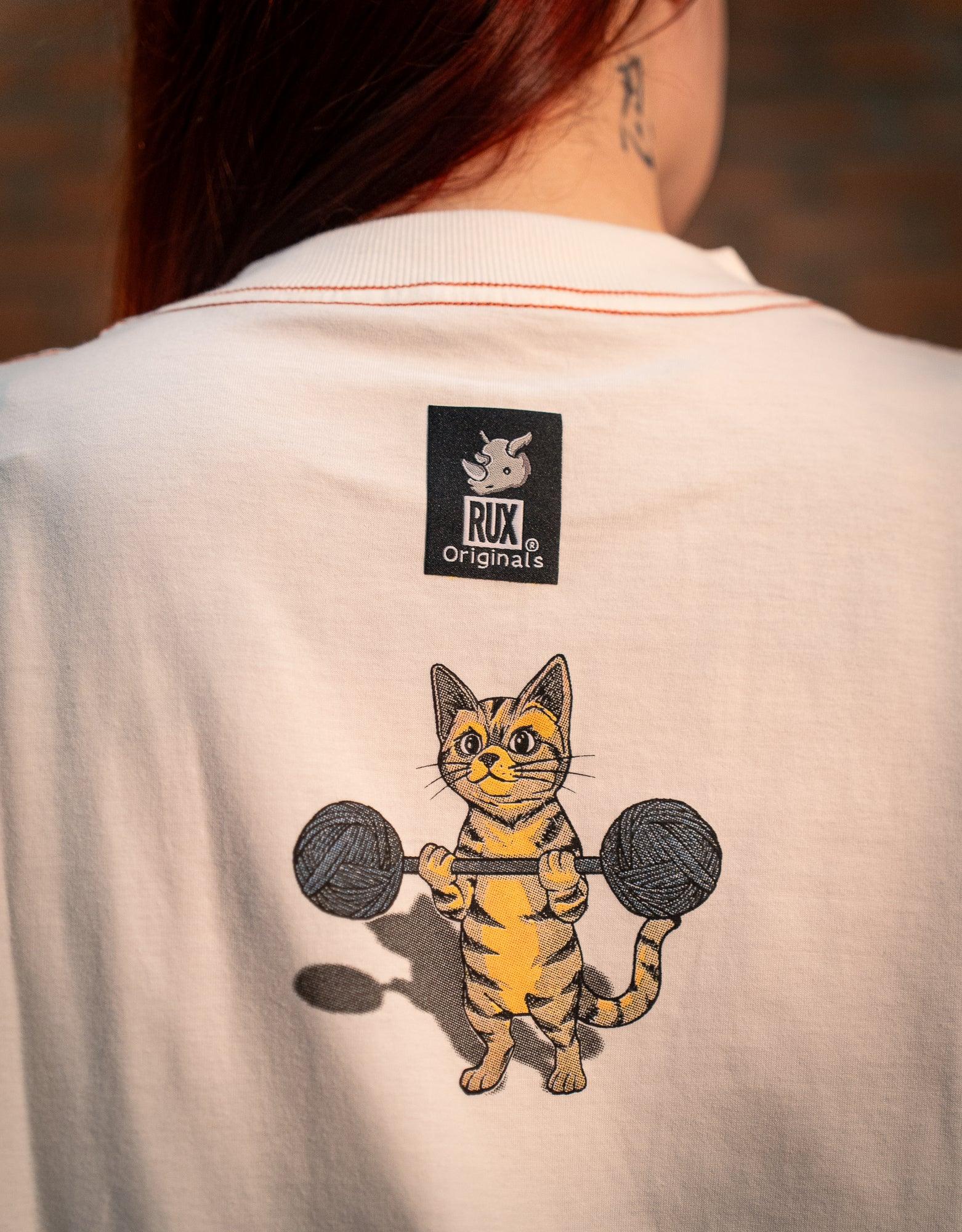 Back view of model wearing white shirt with cartoon cat lifting weights print