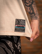 Model wearing patterned workout pants with a close-up of a tattooed hand and shirt hem patch