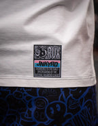 Model wearing patterned pants with blue cartoon faces and white shirt with visible label.