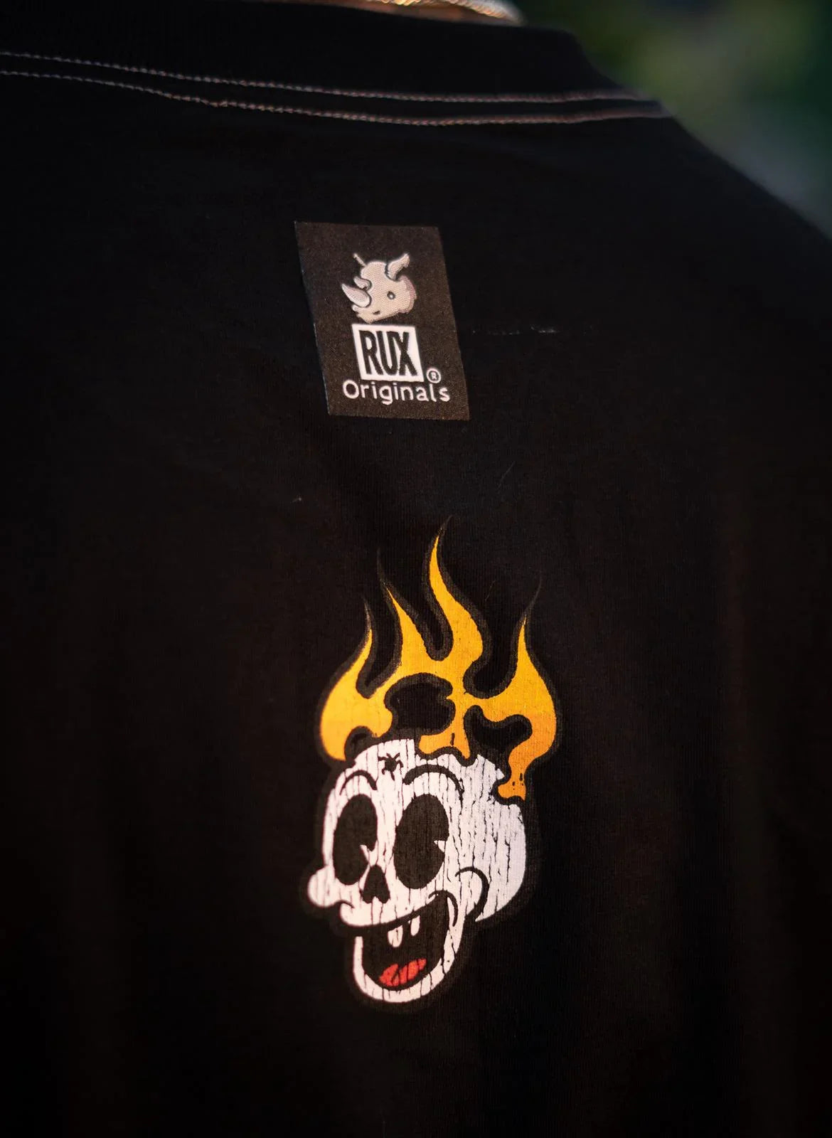 Black shirt with flame skull graphic and visible clothing label