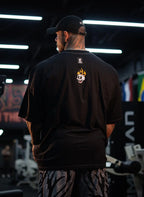 Model wearing bold patterned pants, seen from the back in a gym setting